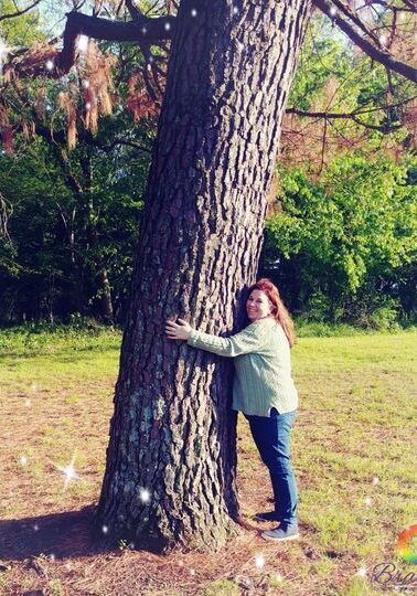 Brandi Lei, Metaphysical Minister and Spiritual Life Coach hugging a tree